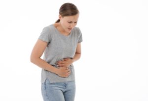 Woman holding stomach on white background