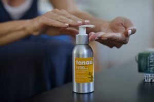 woman using Tanasi cbd lotion on hands