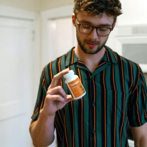 Man holding Tanasi CBD pill bottle