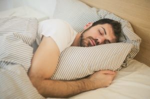 Man holding pillow sleeping