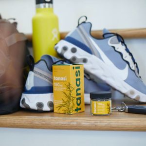 Tanasi CBD salves with running shoes and water bottle