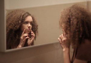 woman applying face serum to skin