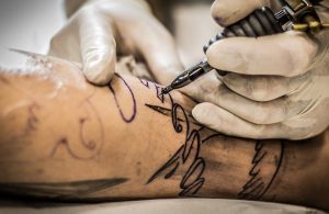 Tattoo artist creating a tattoo on skin