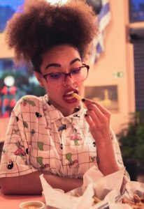 Woman in restaurant eating fries