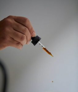 CBD oil dropper being used for haircare