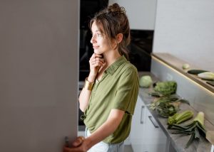 Woman looking into fridge after intermitten fasting