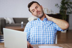 Man in blue shirt with a dystonia neck cramp