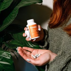 Woman holding CBD pills