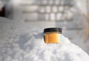 CBD salve container in snow drift